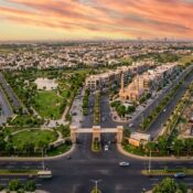 A modern aerial view of Etihad Town Phase 4 showing residential plots, commercial blocks, landscaped roads, parks, and modern infrastructure in Lahore.